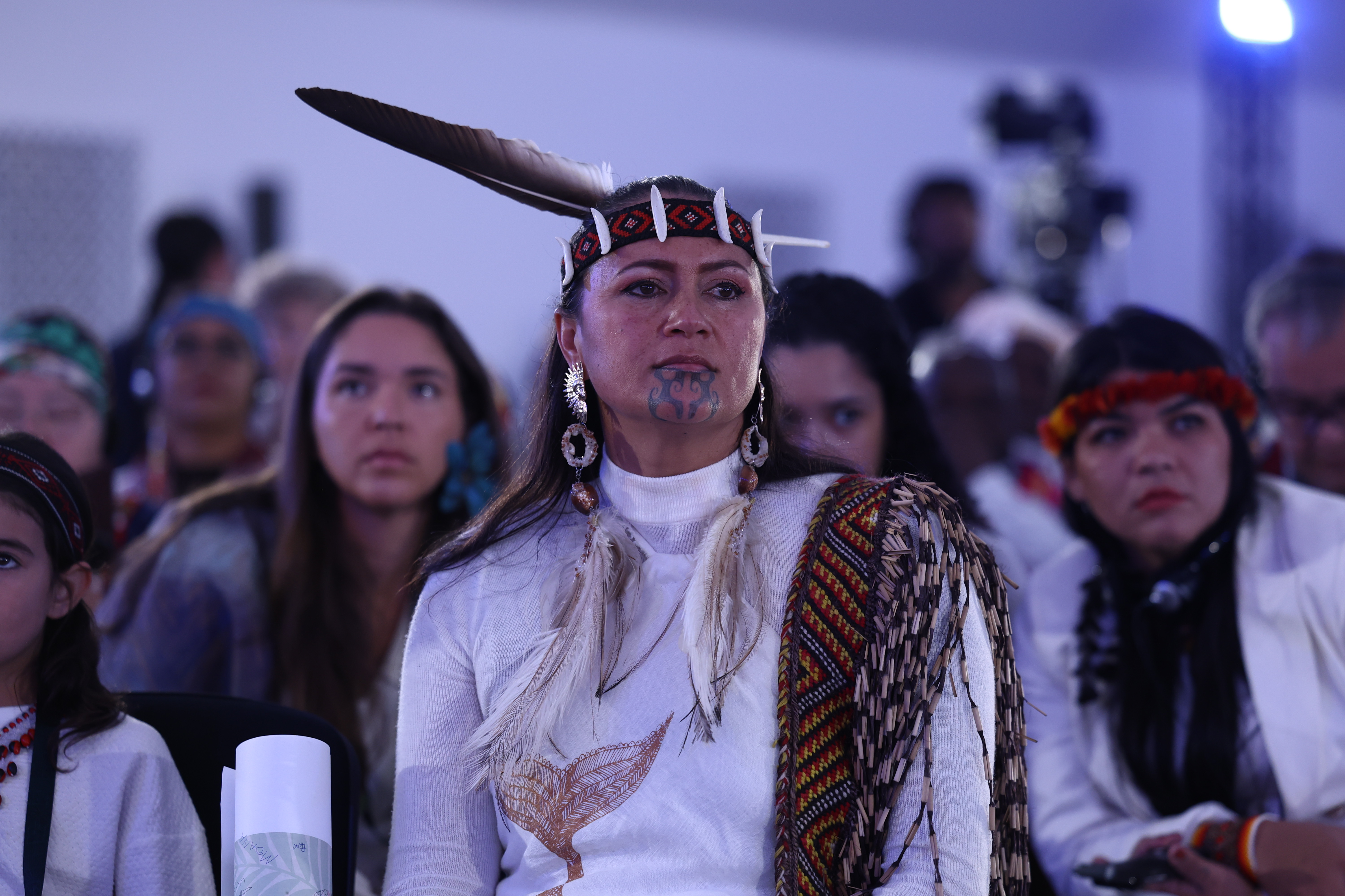 person in traditional headpiece in auditorium